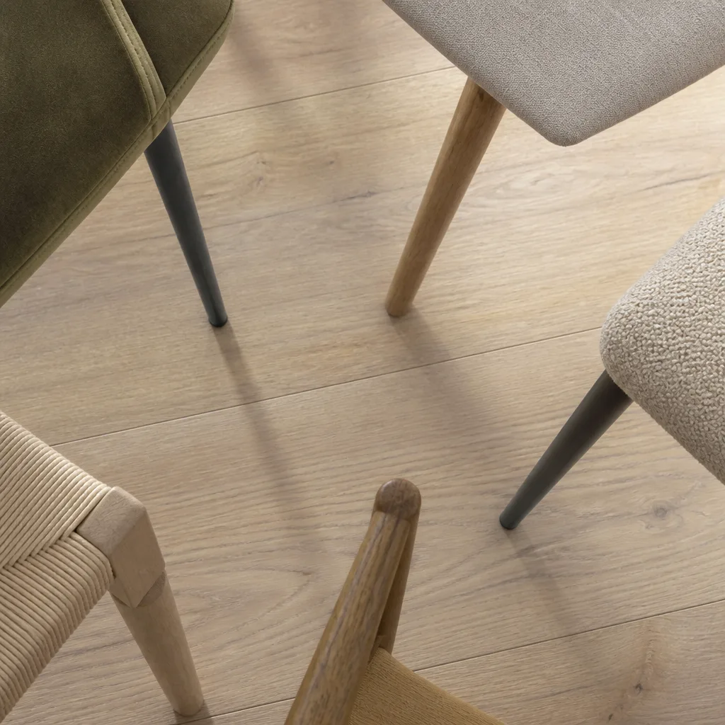 Overhead flat lay of dining chair legs on a light wooden floor showing different leg finishes